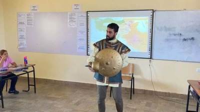 معلم يرتدي الدرع والخوذة خلال شرح قصة دولة المماليك لمعايشة الطلاب للتاريخ